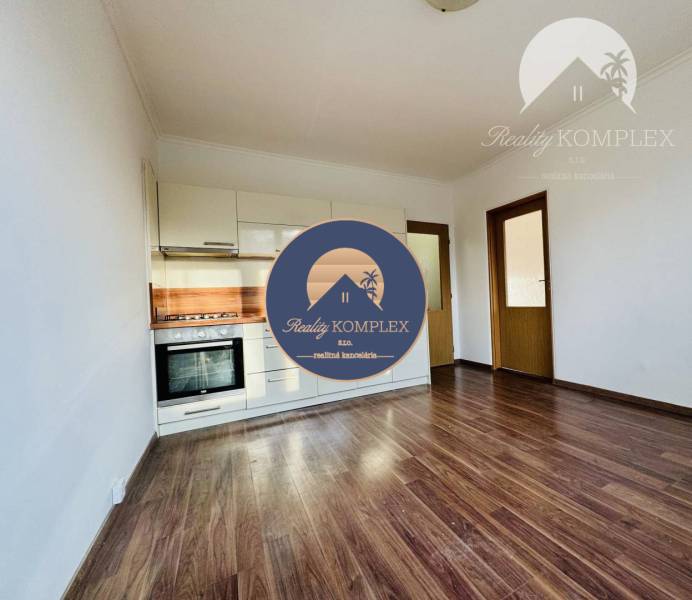 Interior of a 1-room apartment with a kitchen and a wooden decor floor.
