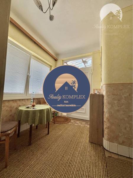 Interior of a family house with carpet flooring, a table, and a chair.