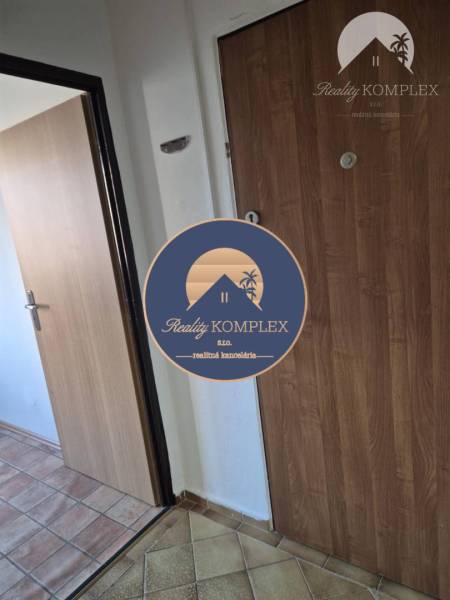 Entrance hallway in a one-room apartment with a wooden decor floor and ceramic tiles.