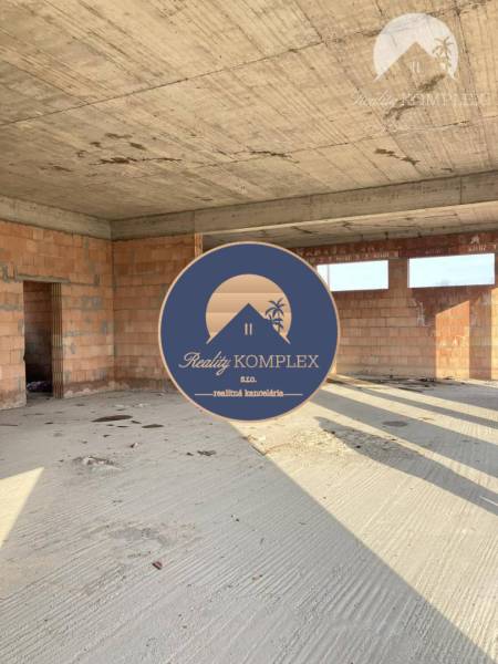 An unfinished building with bare walls and ceiling, view into the interior of a family house.
