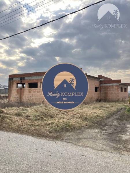An unfinished family house in Zlatná na Ostrove on an open plot under a cloudy sky.