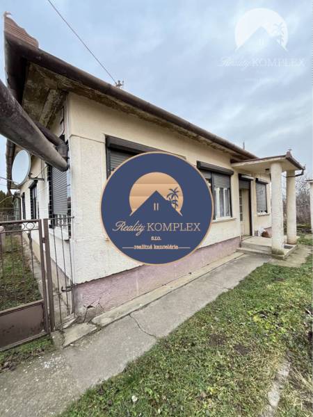 A family house in Strekov with a garden, accessible by a concrete walkway.