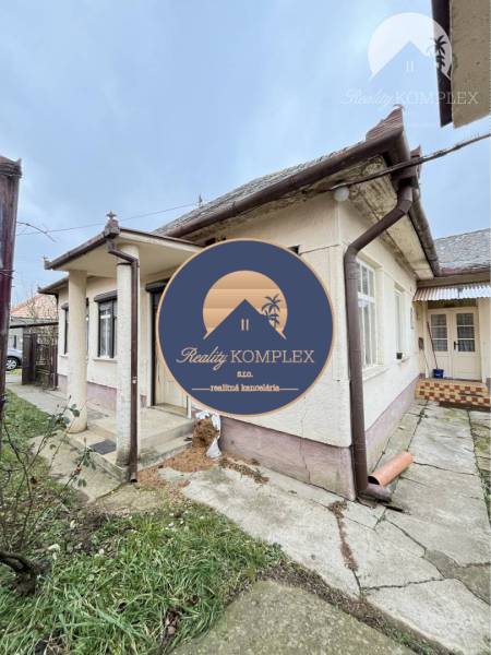 A family house in the town of Strekov with a stone pathway and a plastered facade in the background.