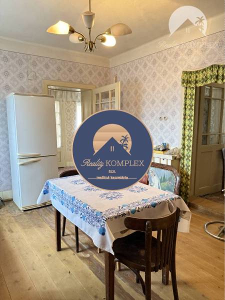 Interior of a family house with a wooden decor floor and a dining table.