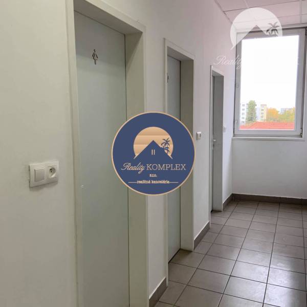 Commercial space with tiles, white doors, and a window, bright room.