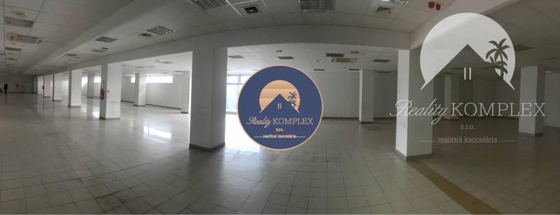 Interior of commercial spaces with tiled flooring, white walls, and columns.