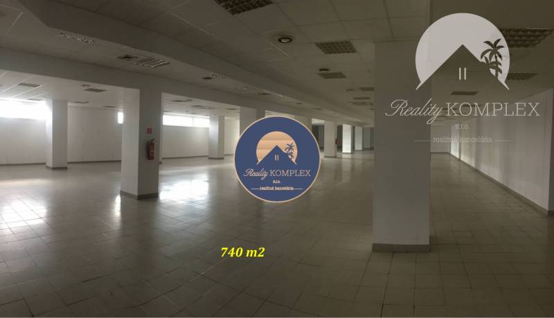 Spacious commercial spaces with bright walls and columns, tiled floor.