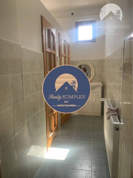 Bathroom with tiles, sink, and wooden door in the area of Warehouses and halls.