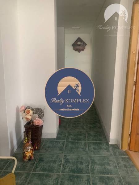 A hallway with green tiles and a decorative floral arrangement in warehouses and halls.