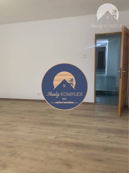 Interior with wood-patterned flooring and open doors in warehouse and hall spaces.