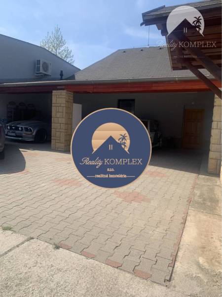 Parking lot on Main Street in Chotín with a car shelter near the warehouse halls.