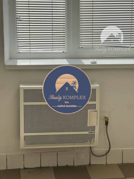 Radiator under the window with blinds in commercial premises.