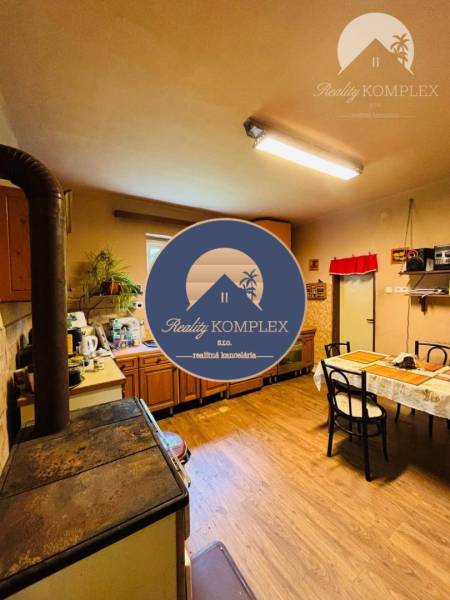 Kitchen with wooden floor, tiles, and dining table. Property - living.