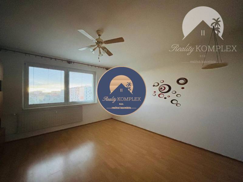A room in a 3-room apartment with wall decorations and a view of the city.
