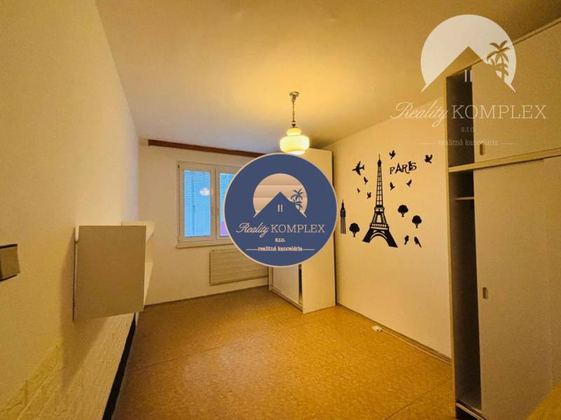 A room in a 3-room apartment with a sticker of the Eiffel Tower on the wall.