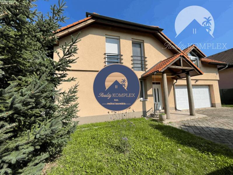 A family house in Dunajská Streda with a garage and a front garden, surrounded by greenery.