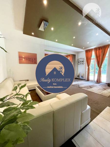 Living room in a family house with a white sofa and large windows.