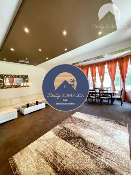 Living room in a family house with a white sofa, curtains, and a coffee table.