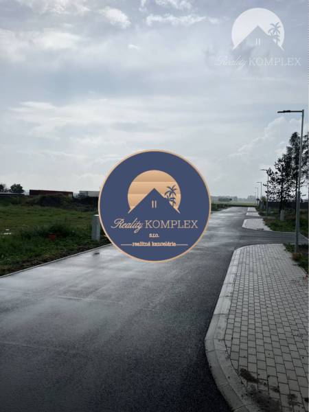 Asphalt road on Bučuháza in Šamorín, surrounded by plots designated for housing.