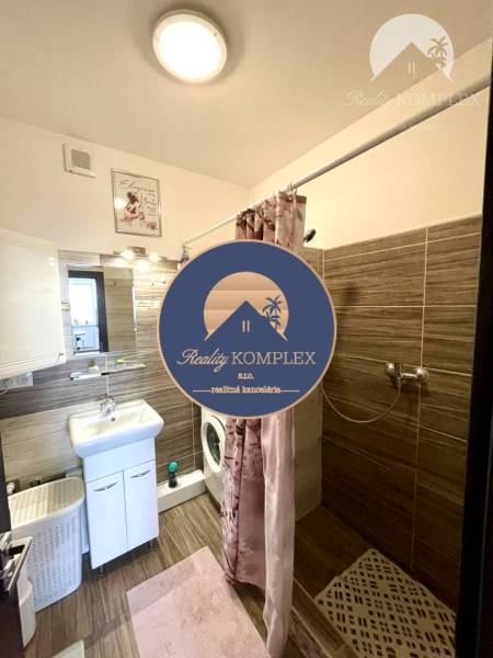 Bathroom in a 2-room apartment with a bathtub, sink, and washing machine.