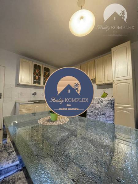A kitchen with a glass table and beige cabinets in a family house.