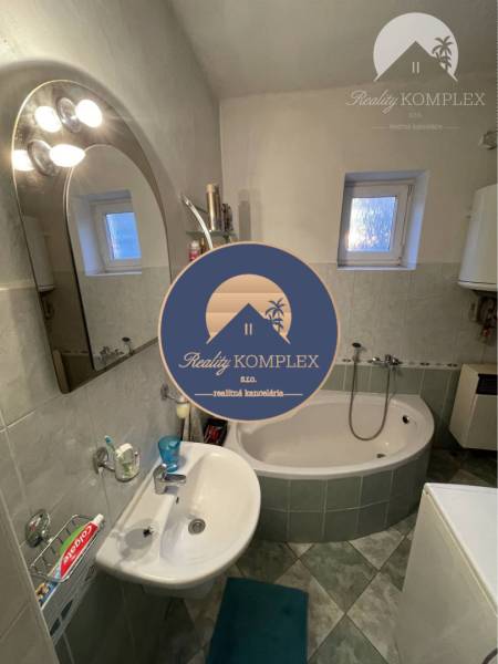 Bathroom in a family house with a bathtub, sink, and window.