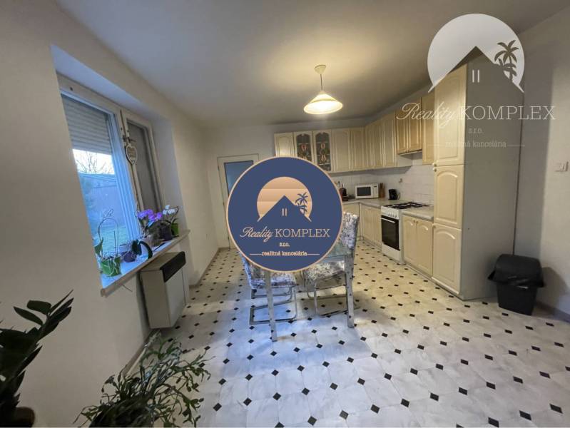 The kitchen in a family house with a dining table, window, and kitchen unit.