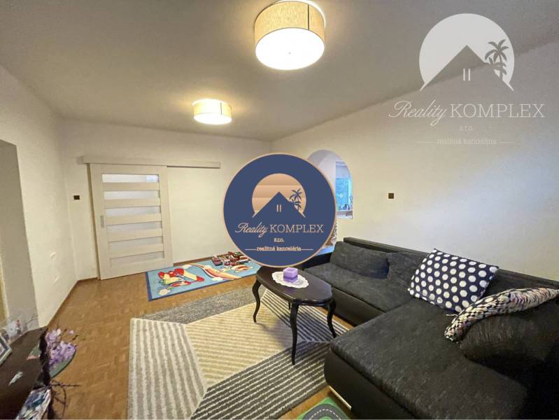 Living room in a family house with a wooden decor floor and a comfortable sofa.