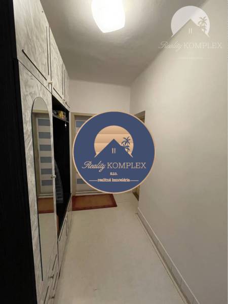 A narrow hallway with white furniture and spot lighting in a family house.
