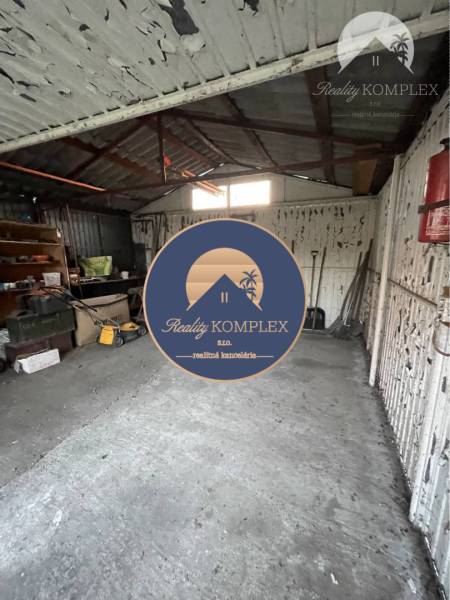 A garage in a family house in Vrakúňa with a concrete floor and stored tools.