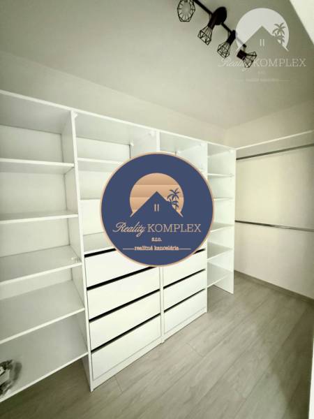 A wardrobe in a family house with white shelves and a wooden decor floor.