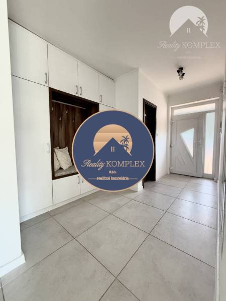 The entrance hall of a family house with white built-in wardrobes and tiles.