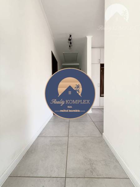 A hallway with white walls and light tiles in a family house.