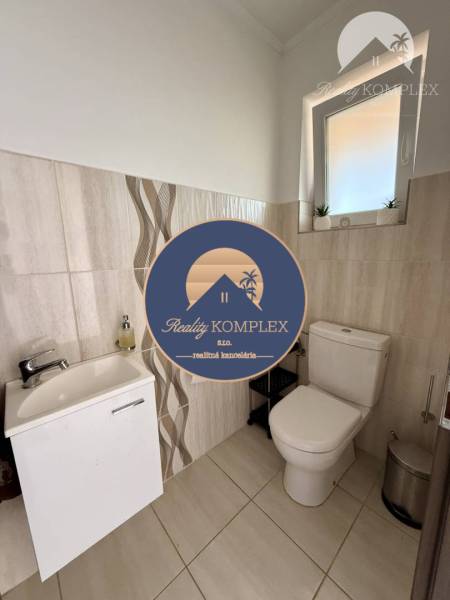 A bathroom in a family house with ceramic tiles and a modern sink.