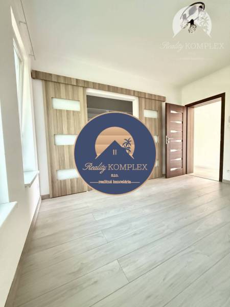 A room with doors featuring glass elements and a floor with a wooden decor in a family house.