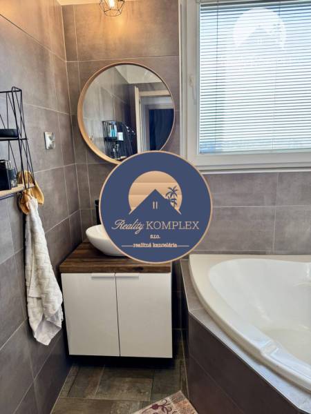 A bathroom in a 4-room apartment with a sink, mirror, and bathtub, decorations on the shelf.