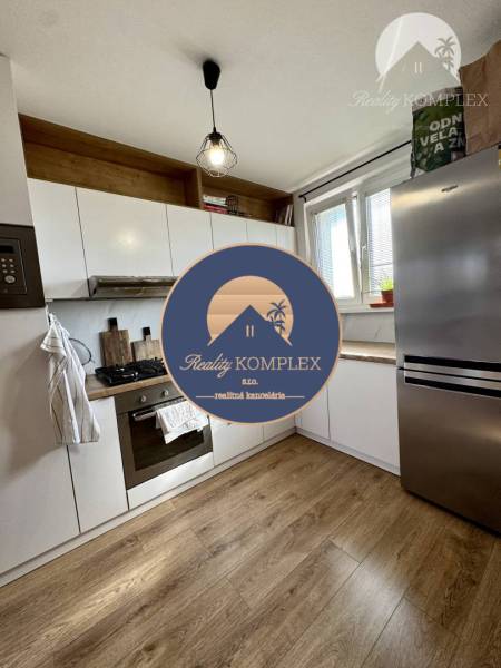 Kitchen in a 4-room apartment with wooden flooring, white cabinets, and stainless steel appliance.