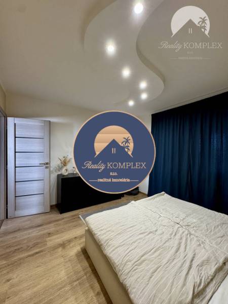 A bedroom in a 4-room apartment with light wooden furniture and curtains.