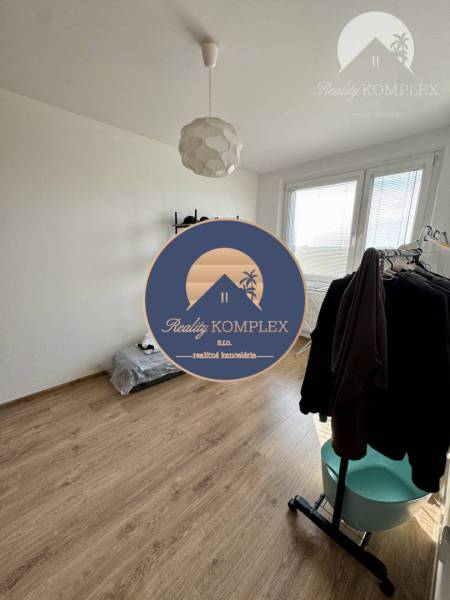 A room with white walls and a wooden floor in a 4-room apartment.