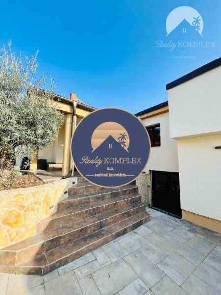 A family house with a terrace, stairs, and a stone-clad wall, ideal for a peaceful life.