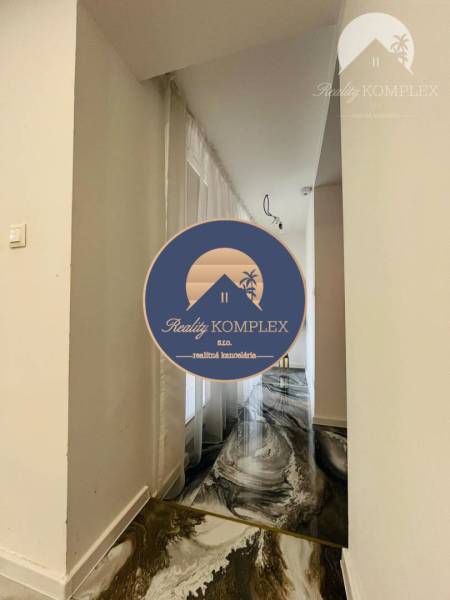 Elegant hallway in a family house with patterned flooring and a plant in the hallway.