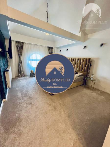 A bedroom in a family house with lighting effects, a couch, and a comfortable bed.