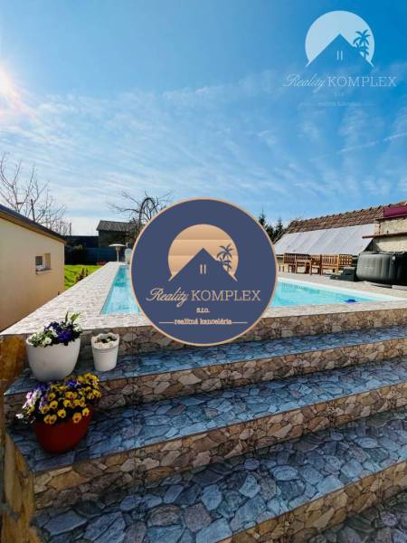 In the garden by the family house, there is a pool, stone steps, and flower pots with flowers.