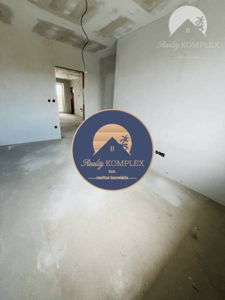 An empty room awaiting completion in a 3-room apartment with a wooden decor floor.