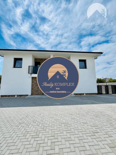 The exterior of a family house in the town of Veľký Meder with a paved access area.