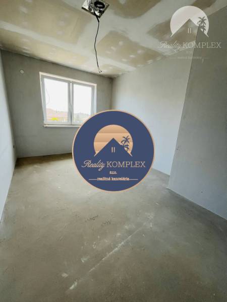 A partially finished room in a 3-room apartment with a concrete floor and a window.