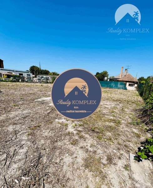 A plot for residential use in Veľký Meder with a view of the surrounding architecture.