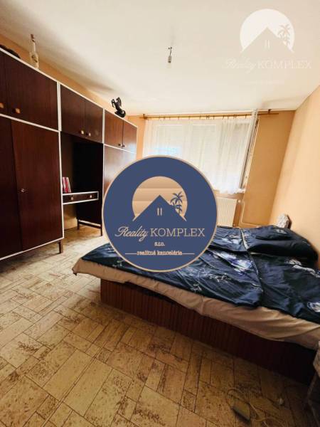 Bedroom with wood-patterned flooring and storage spaces in a family house.