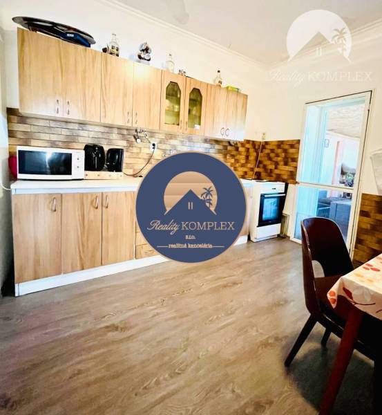 A kitchen in a family house with wooden decor and basic appliances.