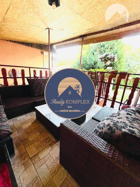 The terrace of a family house in Okoč with comfortable rattan furniture.